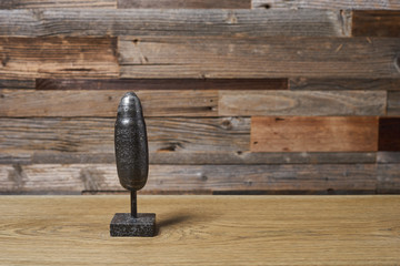 the mineral pyrite is a cylindrical figurine on a wooden background