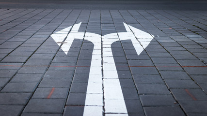 arrow symbol on forked road. make choice which way to go