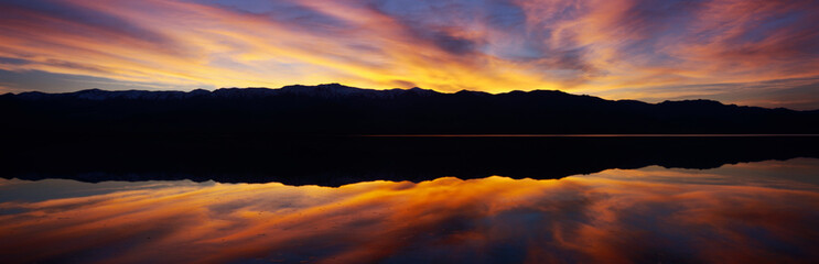 Wall Mural - Panoramic view at sunset of flooded salt flats and Panamint Range Mountains in Death Valley National Park, California