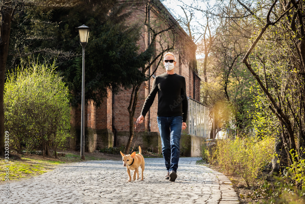 dog with  leash and owner with face mask walking outside - obrazy, fototapety, plakaty 