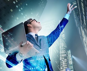 Businessman with laptop against the building