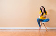 © Tierney - Young woman using her tablet sitting in a chair