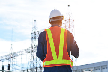 Asian Engineer Construction are Worker employee Worker By safety control helmet on site building,Engineer holding Computer against building Electrical