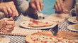 Closeup of young woman eating delicious pizza at their girlish party