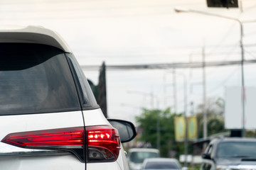 The car rear light illuminates the road when the brake is on. Traffic conditions on rural urban roads.