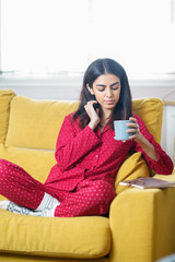 Wall Mural - Woman at home having tea and reading