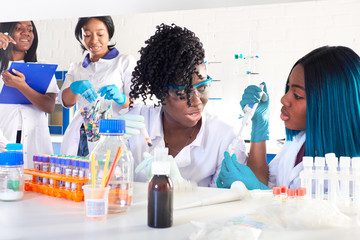 Wall Mural - Testing facility. Young African female scientists, medtech or medical students work together performing blood, nucleic acid and other medical tests for hospitals to diagnose patients with pneumonia.