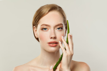 Wall Mural - Perfect young woman face and aloe vera leaf on white background