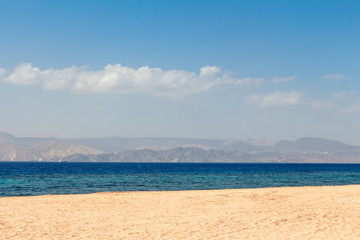 Sandy beach - Japanese Gardens in Jordan. White sand. Mountains can be seen in the distance.