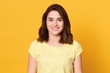 © sementsova321 - Image of cheerful positive good looking young female smiling sincerely, having pleasant facial expression, looking directly at camera, wearing yellow t shirt, standing isolated over yellow background.