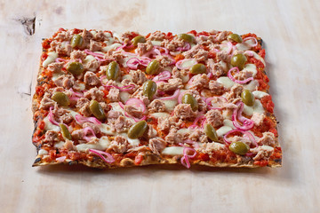 Delicious traditional Tarte Flambee from the Alsatian region of France with a thin crust of dough, tuna