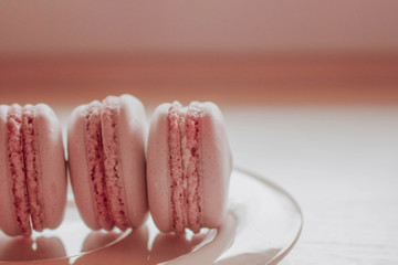 Strawberry french macarons closeup. Fresh and colourful on pink background