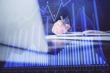 Double exposure of businessman with laptop and stock market forex chart.