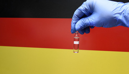 Wall Mural - Corona virus or Covid-19 in Germany , sample blood tube in hand with Germany flag on background