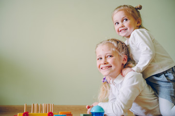 Wall Mural - Little girls play a building plastic blocks. Logic game for children.