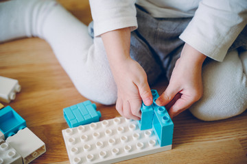 Wall Mural - Little girl play a building plastic blocks. Logic game for children.