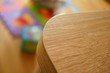 Closeup shot of a curved edge of a wooden table with a blurred background
