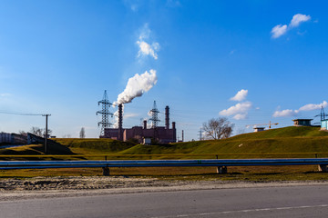 View on smoke pipes of the factory against blue sky. Environmental pollution