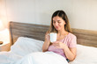 © Andrei - morning relaxation. young relaxed woman in her bed enjoying a cup of coffee or tea. stay at home and enjoy life