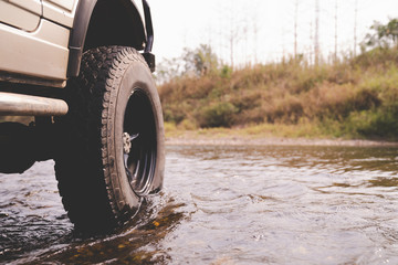 Wall Mural - Part of the off-road vehicle parked in the river with warm light. adventure concep.off-road car.