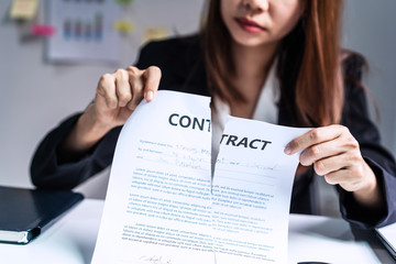 business woman tearing contract at her office, breaking contract concept