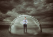 Businessman safely inside a shield dome during a storm that protects him. Protection and safety concept