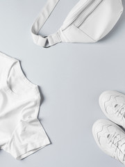 Wall Mural - Fashion flat lay with white t shirt, sneakers, waist bag and accessories, monochrome concept, casual look.