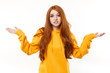 © ViDi Studio - Perplexed displeased young redhead woman girl in casual yellow hoodie posing isolated on white wall background studio portrait. People emotions lifestyle concept. Mock up copy space. Spreading hands.
