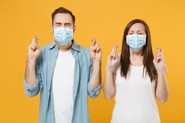 Two people in sterile face masks white t-shirts isolated on yellow background studio. Epidemic pandemic rapidly spreading coronavirus 2019-ncov medicine flu virus ill sick disease treatment concept.