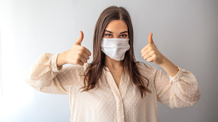 Girl in respiratory mask. Masked attractive woman looks at camera. Cold, flu, virus, tonsillitis, acute respiratory disease, quarantine, epidemic concept. Beautiful caucasian young woman with disposab