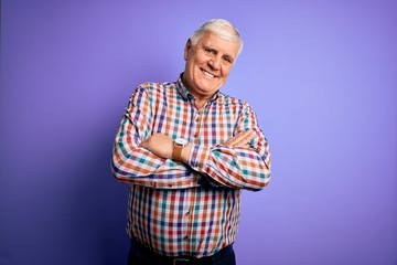 Senior handsome hoary man wearing casual colorful shirt over isolated purple background happy face smiling with crossed arms looking at the camera. Positive person.