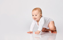 Chubby Ginger Baby Boy In Bodysuit, Barefoot. He Smiling, Creeping On Floor Isolated On White Background. Close Up, Copy Space