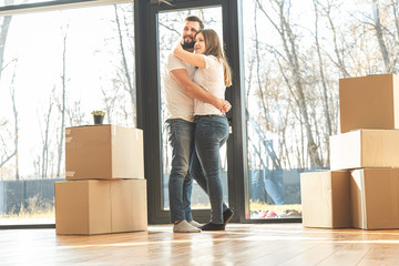 Wall Mural - young couple moves to a new home. the family carries boxes of things after buying a home.