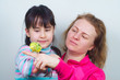© dobryachok839 - mother and daughter communicate with their tame yellow parrot.