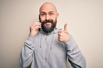 Sticker - Handsome bald man with beard having conversation talking on the smartphone happy with big smile doing ok sign, thumb up with fingers, excellent sign