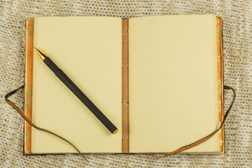 Vintage leather-bound notebook and pen on a light background with copy space