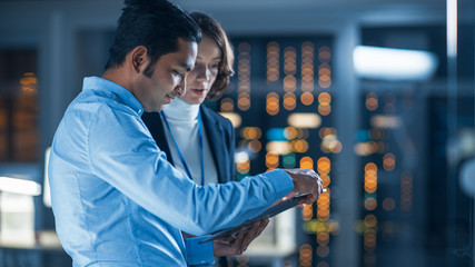 Poster - In Technology Research Facility: Female Project Manager Talks With Chief Engineer, they Consult Tablet Computer. Team of Industrial Engineers, Developers Work on Engine Design Using Computers