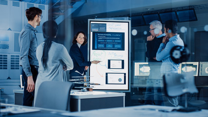 Poster - Engineers Meeting in Research Laboratory: Female Engineer Leads Presentation Writes on Interactive Digital Whiteboard, Shows Blueprint, Data Analytics and Neural Network while Colleagues Listening