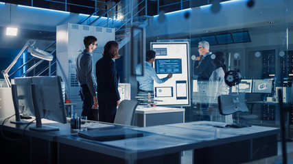 Poster - Engineers Meeting in Technology Research Laboratory: Engineers, Scientists and Developers Gathered Around Illuminated Conference Table, Talking and Finding Solution. Industrial Design Facility