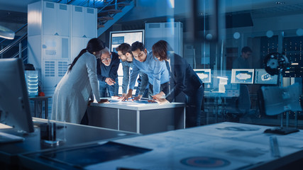Leinwandbilder - Engineers Meeting in Technology Research Laboratory: Engineers Scientists and Developers Gathered Around Illuminated Conference Table, Talking and Finding Solution, Inspecting Industrial Engine Design