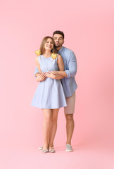 Poster - Happy young couple with hearts on color background