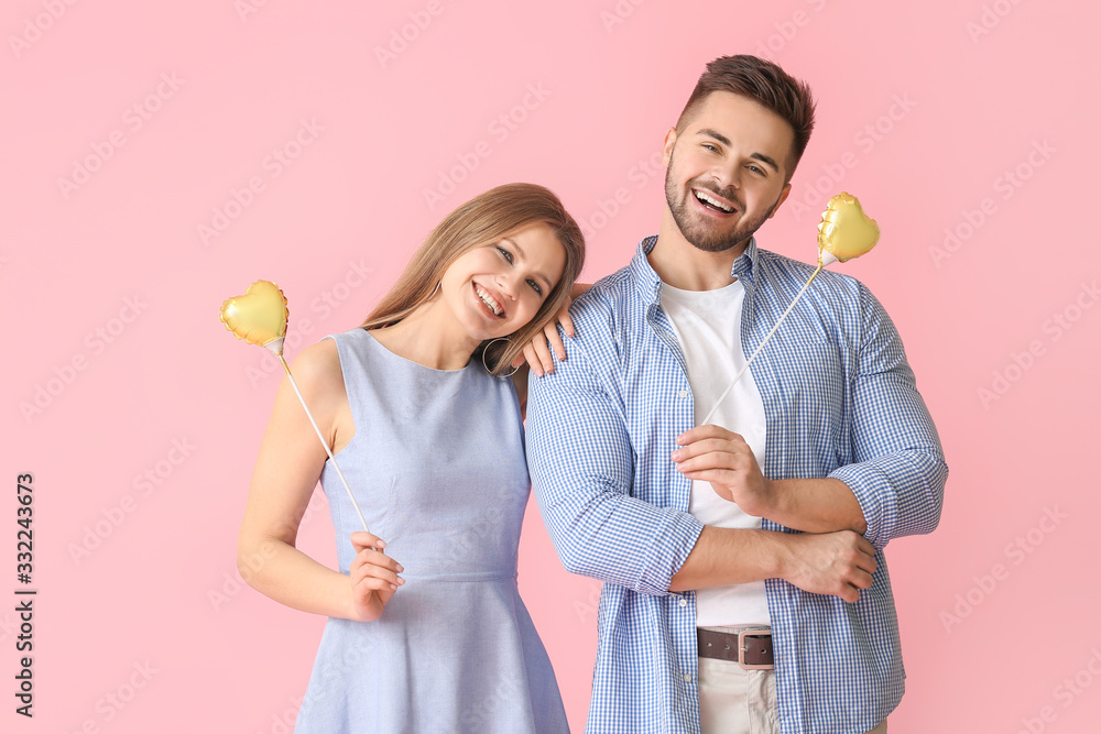 Happy young couple with hearts on color background