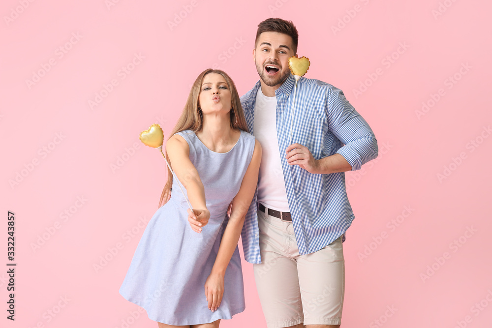 Happy young couple with hearts on color background