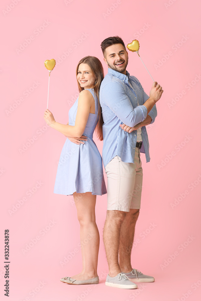 Happy young couple with hearts on color background