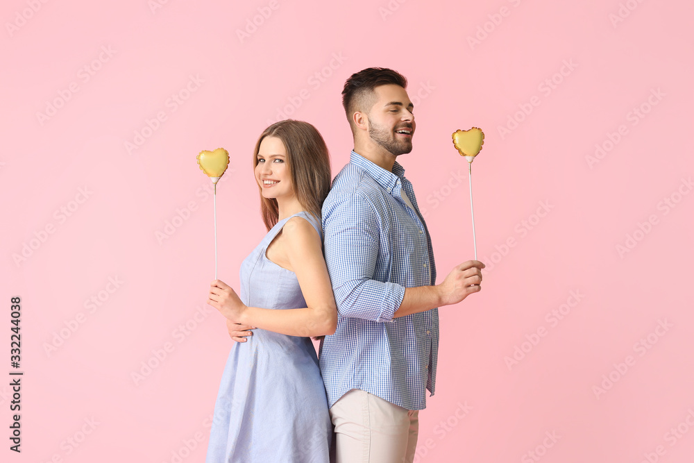 Happy young couple with hearts on color background