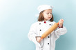 © AntonioDiaz - Gorgeous little girl wearing a chef uniform and aspiring to be a chef in a studio