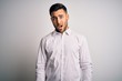 © Krakenimages.com - Young handsome man wearing elegant shirt standing over isolated white background In shock face, looking skeptical and sarcastic, surprised with open mouth