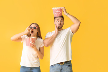 Sticker - Emotional young couple with popcorn on color background