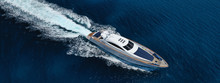 Aerial Drone Top Down Photo Of Luxury Yacht With Wooden Deck Anchored In Open Ocean Sea