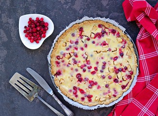 Wall Mural - Dessert, homemade tart or pie with cranberries, apples and tender sour cream or pudding in a baking dish on a dark concrete background.